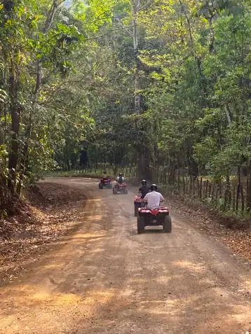 Travelers riding premium ATVs on a dirt trail through the lush jungle near Jacó, Costa Rica. This popular adventure is a top choice for budget-conscious travelers looking to maximize their trip value, often booked as part of a money-saving combo tour package