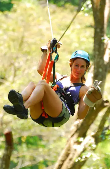 Tourists zip-lining through the lush rainforest canopy near Jacó, Costa Rica