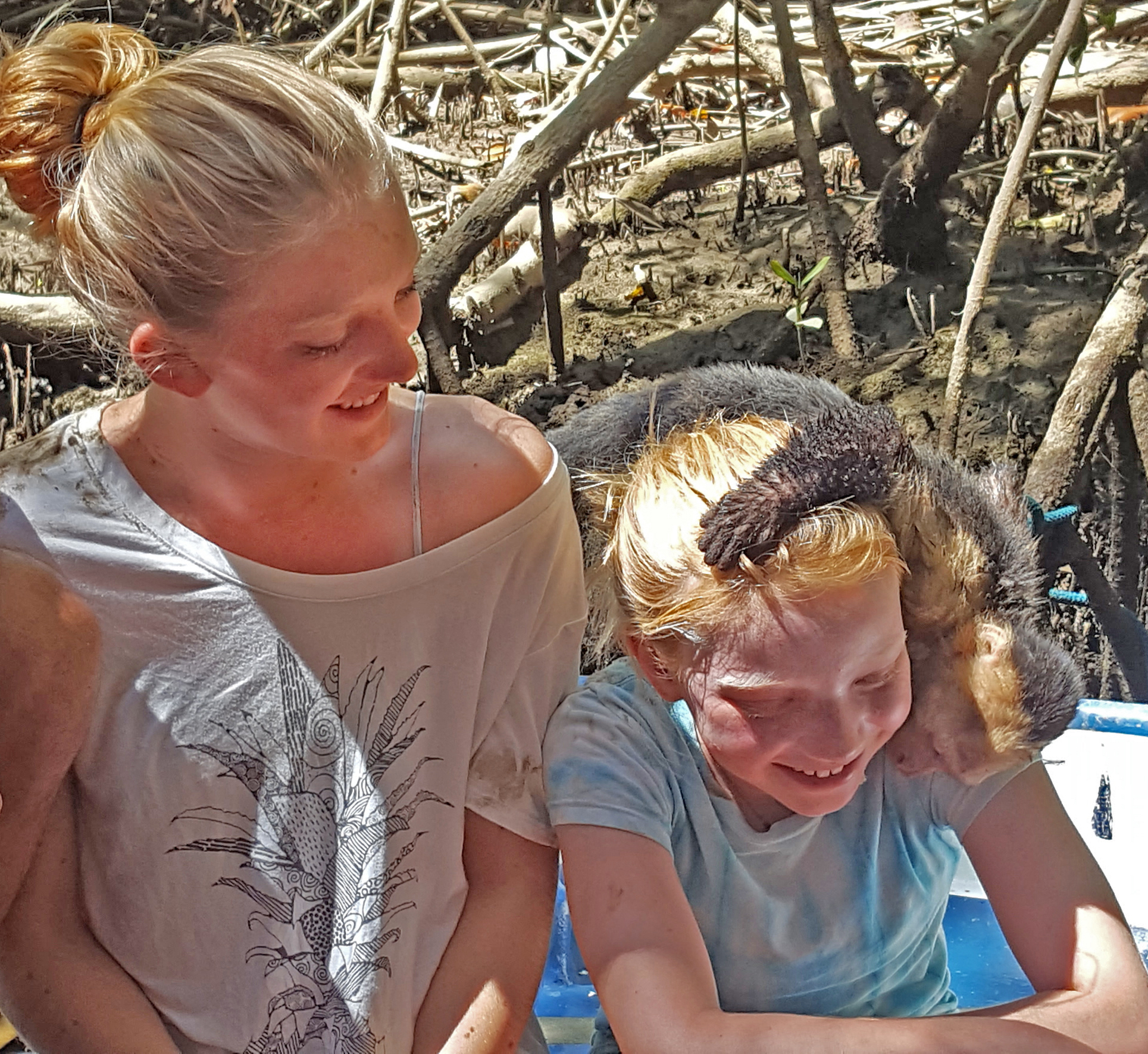 Family with a child watching a capuchin monkey in Manuel Antonio, Costa Rica